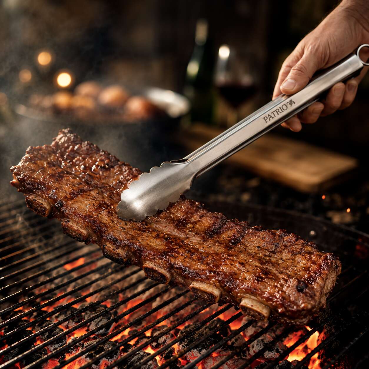 Pinza PATRIO del set de cubiertos, dando vuelta un costillar sobre las brasas